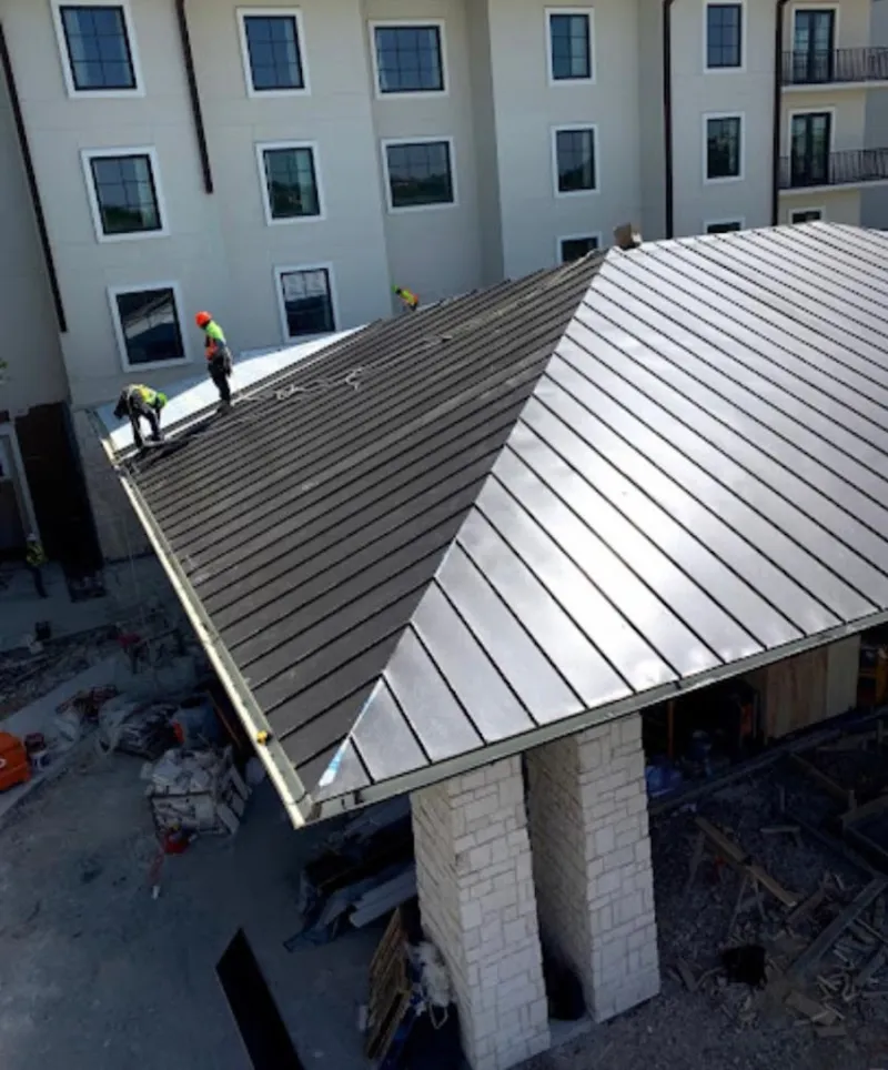 Crew installing standing seam metal roof panels on a commercial project in Helena-West Helena